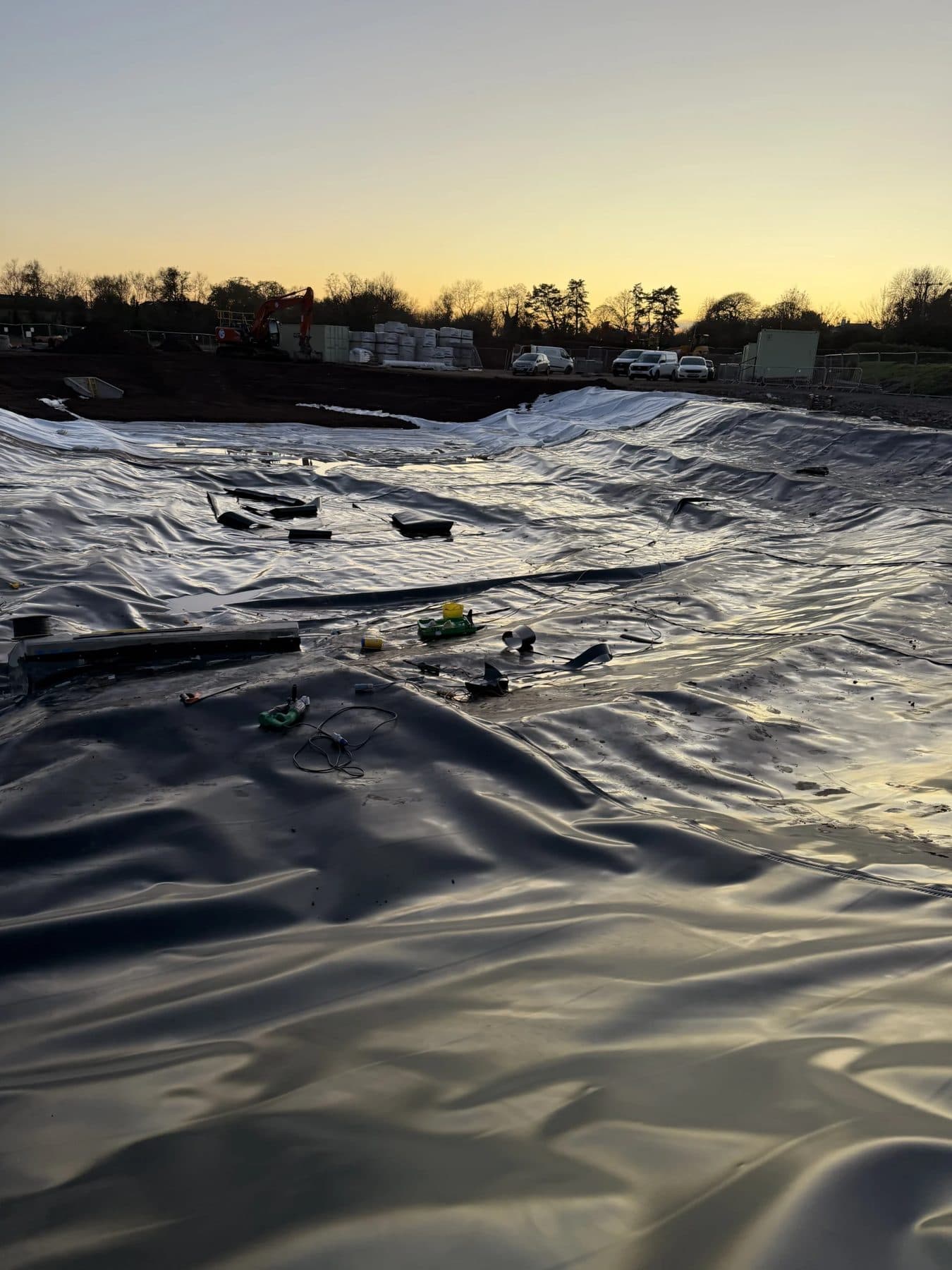 The 3,500m² Worcester attenuation basin lined with welded HDPE membrane, at dusk